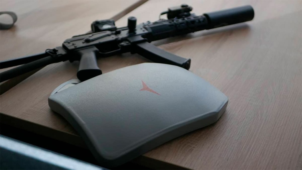 Керамическая бронеплита Atlant Armour на деревянном столе рядом с тактическим оружием