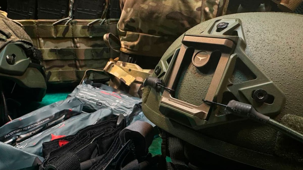 Тактический шлем Atlant Armour с креплением для ПНВ на фоне военной экипировки и аптечек